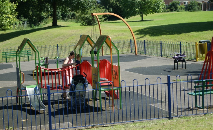 A woman and a child playing in a play area.